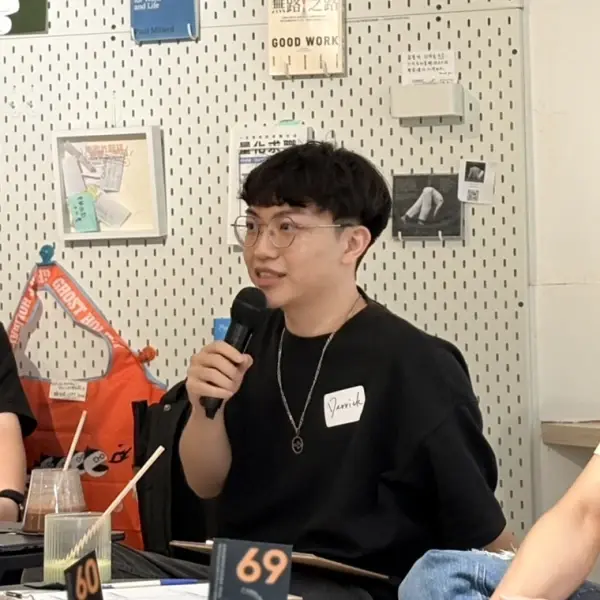 小實現創辦人 Derrick 彭子昂在社群活動上拿著麥克風分享